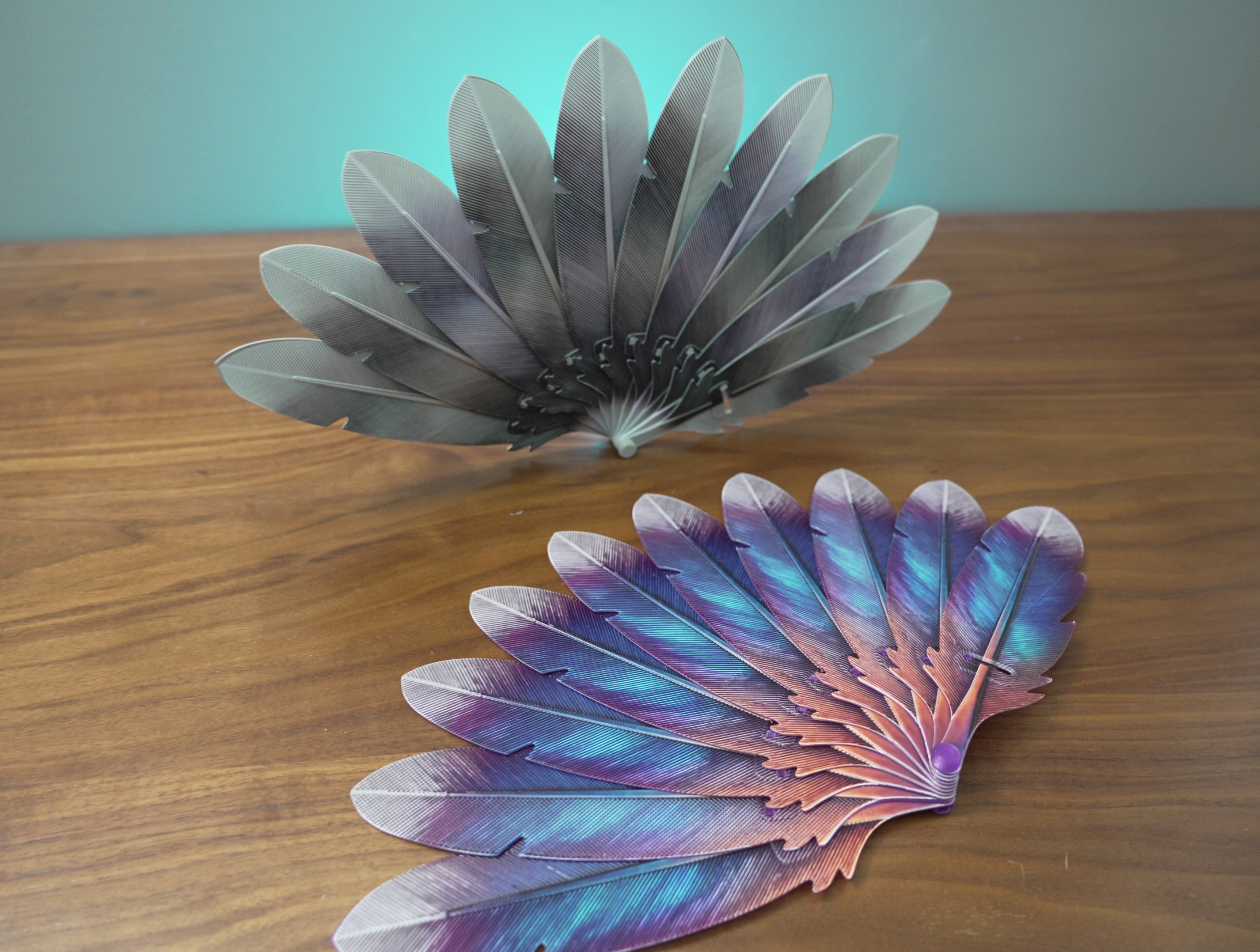 Hand fan with colourful realistic feather design